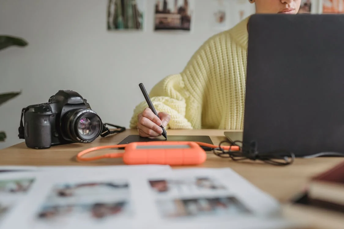 Une femme assise , fait des dessins à l'ordinateur 